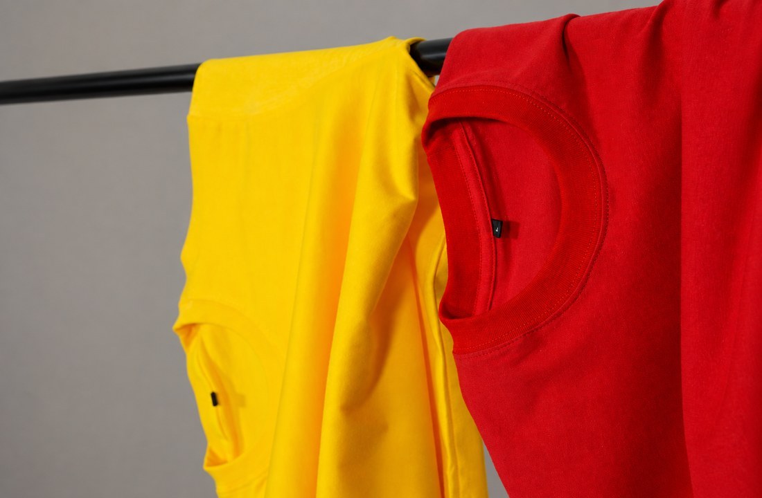 Red and yellow plain T-shirts with visible neckline stitching and fabric texture