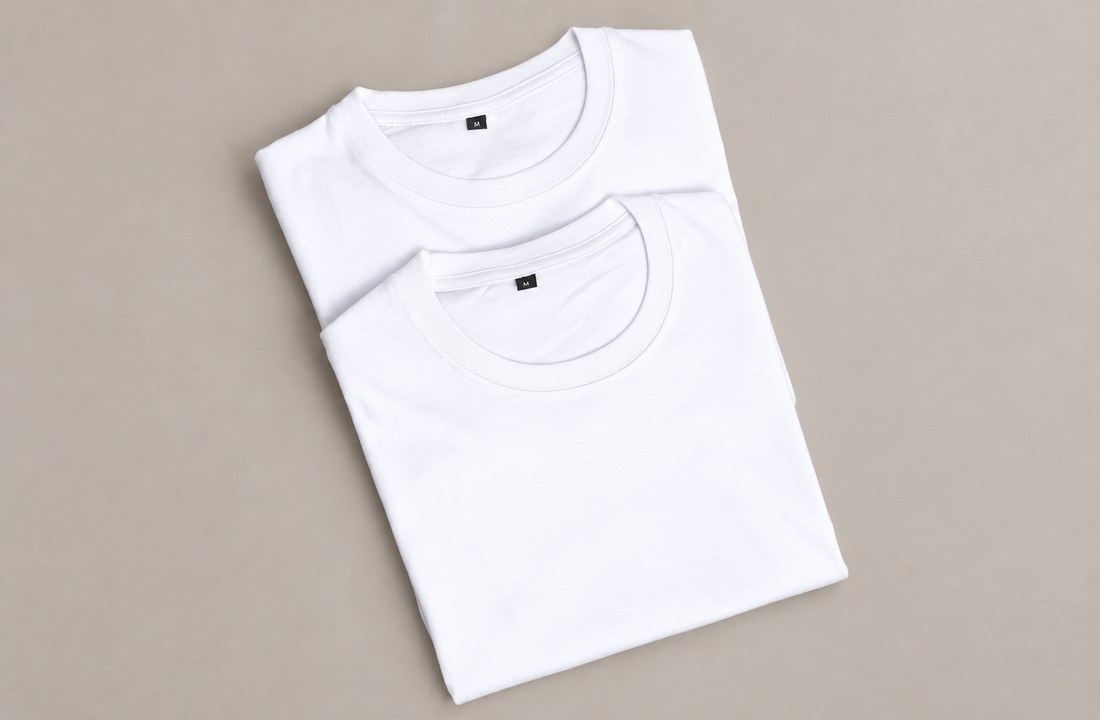 Two folded white T-shirt samples with visible crewneck seams and size labels
