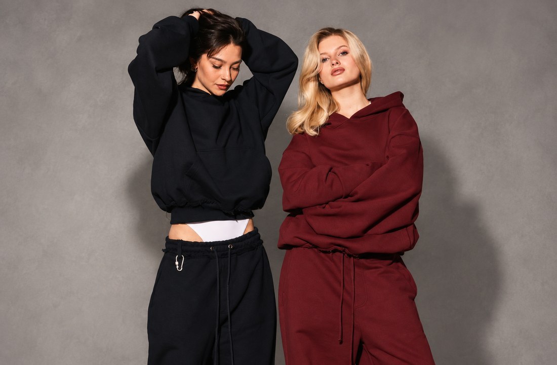 Black and burgundy hoodies with matching sweatpants shown on two models