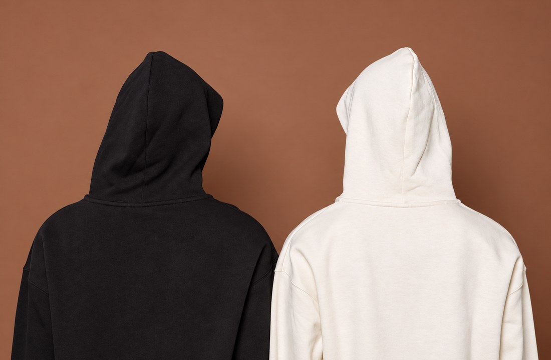Back views of plain black and cream hoodies